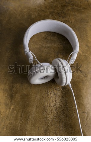 Isolated modern white headphone on a vintage leather background.
