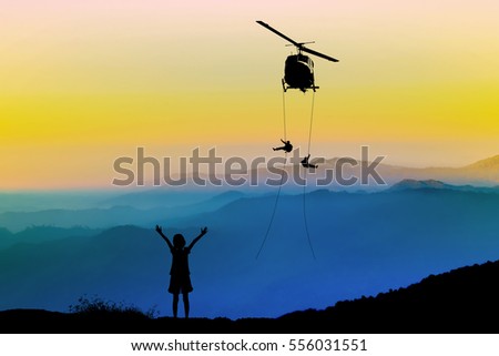 Silhouette of helicopter, soldiers rescue helicopter operations on mountain and sunset sky background.