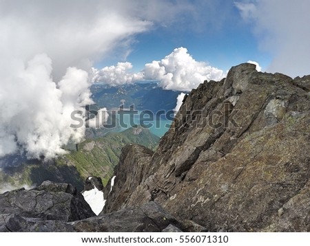 View of Stave Lake far below north face of Mount Robie Reid and overlooking cliffs, Garibaldi Ranges, Mission, British Columbia, Canada Royalty-Free Stock Photo #556071310
