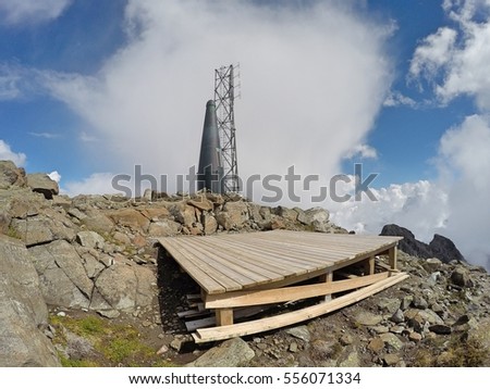 Mountain top helipad, radio transmitter, and storage silo on Mount Robie Reid, Garibaldi Ranges, Mission, British Columbia, Canada Royalty-Free Stock Photo #556071334