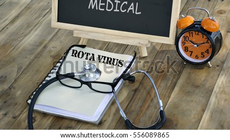 notebook with the words "AUTISM" and stethoscope, glasses, chalk board, alarm clock on a wooden table. medical and health care concept.