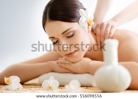 Beautiful, young and healthy woman in spa salon. Massage treatment, traditional medicine and healing concept.