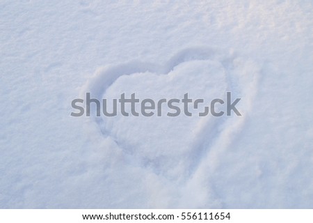 Heart symbol drawn on the pure white sparkling snow