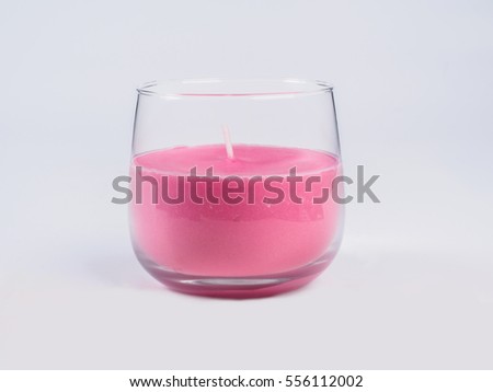 Picture of the pink candle in a glass on white background. Handmade candle in a glass close up.