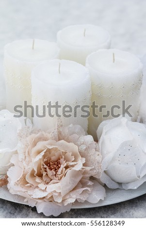 Beautiful winter decorative plate decorated with candles, bulbs, flowers, beads, ribbons and small details pictured on snow. Plate is created in white and pink colors with little additions of gold.