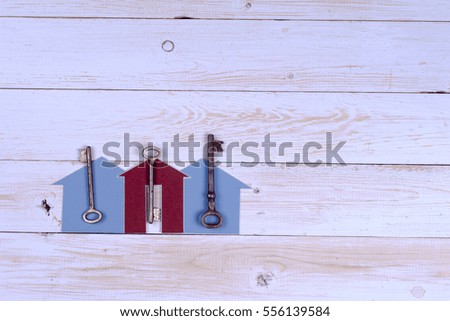 House and key on wooden background. Copy space for text.