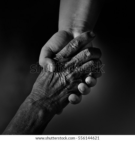 Old and young person holding hands. Elderly care and respect,  Royalty-Free Stock Photo #556144621