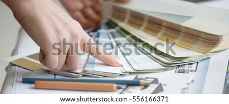 Creative people workplace. Close-up view of hands of young designer woman working with color palette at office desk. Interior shot. Horizontal photo banner for website header design