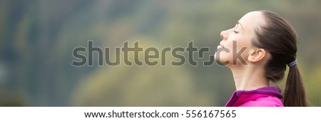 Portrait of a young woman outdoors in a sportswear, head up, her eyes closed. Concept photo, copy space. Horizontal photo banner for website header design with copy space for text