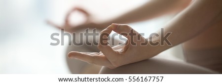 Close-up view of woman doing morning yoga after waking up at home, sitting in Easy pose, Sukhasana posture and meditating. Working out on the bed. Horizontal photo banner for website header design Royalty-Free Stock Photo #556167757