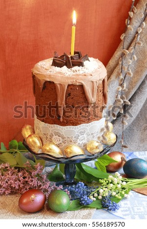 Easter orthodox sweet chocolate bread topped with white icing and colorful eggs on the linen napkin. Easter holidays background with copy space