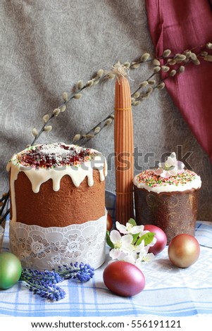 Easter orthodox chocolate cakes, colorful eggs, flowers on the linen napkin. Easter background with the 33 wax candles have been lit from the Holy eternal fire at the Holy Tomb of Jesus in Jerusalem