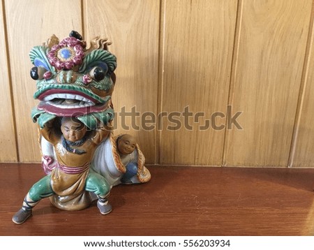 China doll tiger on wood background