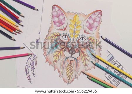 Composition of colouring pictures and pencils, closeup