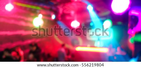 Blurred people inside disco club with colorful laser lights in background - Defocused image - Concept of nightlife with music entertainment - Original color bokeh - Warm vivid filter