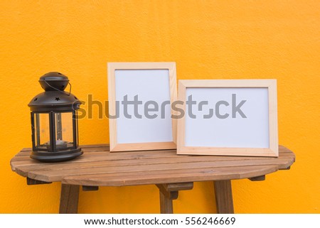 Two photo Frame and lamp on a wooden on Yellow background .
