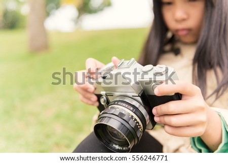 Beautiful Asian Girl Holding Film Camera in the Park