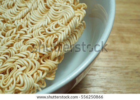 Instant noodles in a white bowl on a wooden table background, Dry keep for scald the hot water, Testy fastfood, Close up