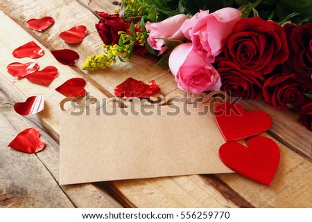 Valentines day background. Beautiful bouquet of roses next to empty letter on wooden table