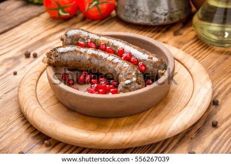 Grilled sausage with fresh rosemary on hot barbecue dish