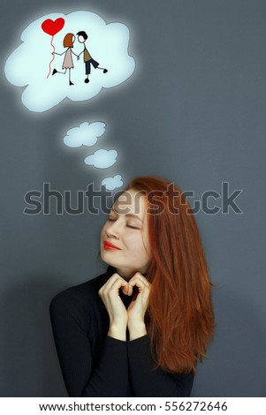 Love and dreams. The girl with red hair on gray background. Royalty-Free Stock Photo #556272646