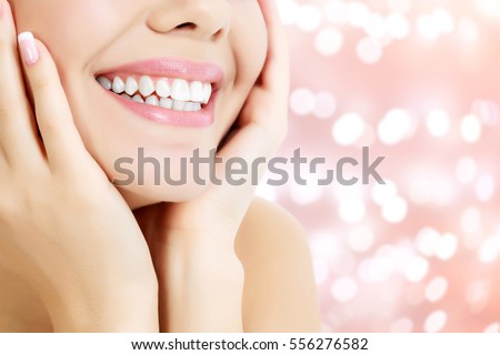 Happy woman smiling on an abstract background with blurred lights Royalty-Free Stock Photo #556276582
