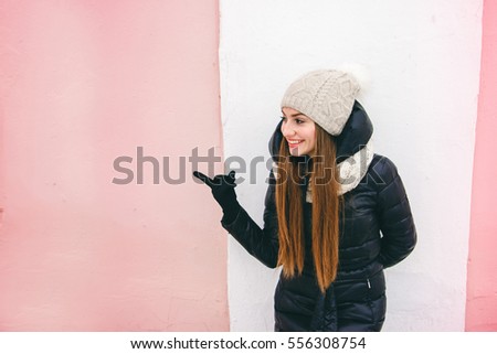 on wall background girl in a hat laughing and pointing her finger