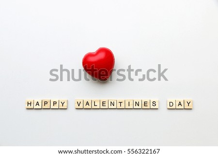 Happy Valentine Day text word made with wood blocks and red heart on table.