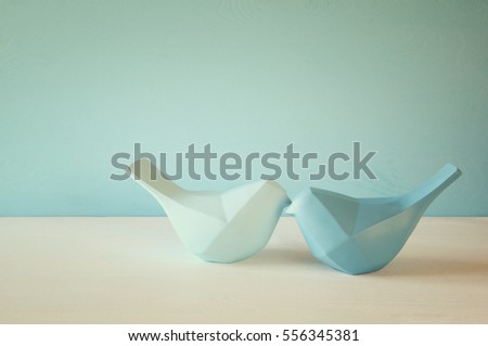 Couple of Lovebirds on wooden table in front of blue pastel background