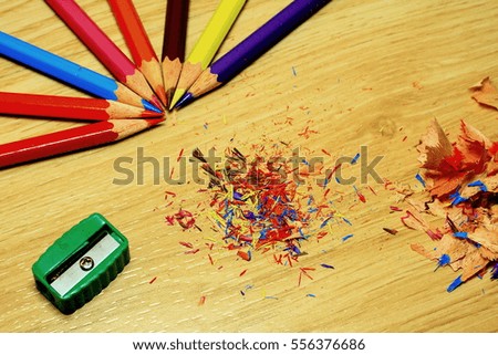 Sharpening a color pencil sharpener On the wooden floor.