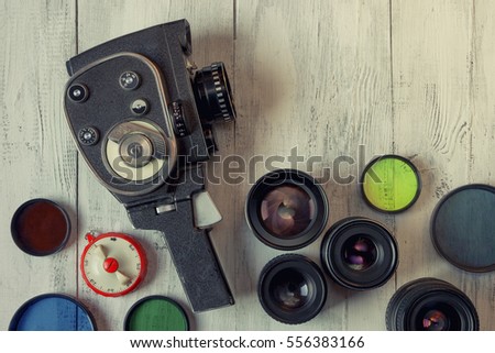 Old movie camera with interchangeable lenses and color filters on the table