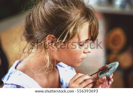 young girl artist painting with oil paints on the stone