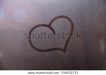 Heart symbol of love drown on the glass 