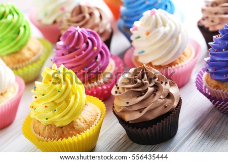 Tasty cupcakes on a white wooden table Royalty-Free Stock Photo #556435444