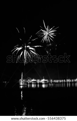 Blurry photo of fireworks over on the Arsenal lagoon during the Carnival celebration in Venice (Italy). Blurred lights. Black and white.