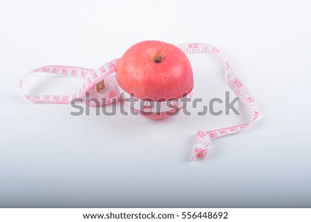 Apple and measuring tape to the body on a white background