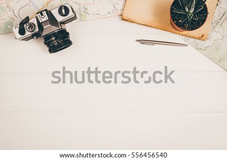 Accessories for travel top view on white wooden background with copy space. Adventure and wanderlust concept image with travel accessories. Preparing for an exotic trip, journey and sightseeing. Royalty-Free Stock Photo #556456540