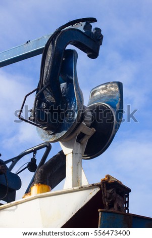 Heavy lifting gear. A heavy duty trawl net winch on a swinging crane arm on a trawler