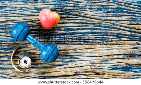 dumbbell and measuring tape and red heart on wooden background,Sport equipment,Healthy lifestyle concept,Still life photography, Top view with copy space