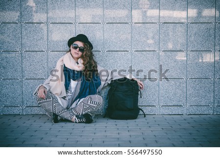 Young beautiful woman sits on the platform while waiting for the train. Toned picture