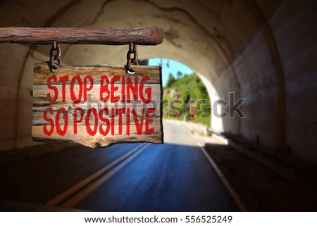 Stop being so positive motivational phrase sign on old wood with blurred background