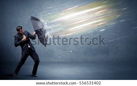 Business man defending light beams with umbrella concept on background