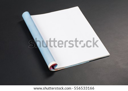 Mock-up magazine or catalog on black chalkboard. Blank page or notepad on black table background. Blank page or notepad for mockups or simulations. Royalty-Free Stock Photo #556533166