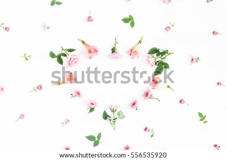 Flowers composition. Heart symbol made of pink flowers and leaves. Top view, flat lay