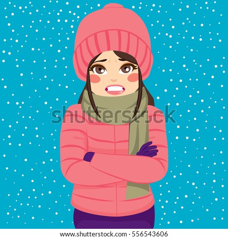 Woman shivering in cold winter outdoors wearing warm clothes on snowy day