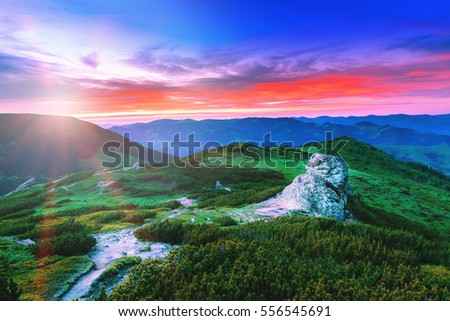 Picturesque sunset landscape in Carpathian mountains. Summer season. Green valleys and hills at glowing sunset scene and dramatic sky background. Artistic post-production photography.