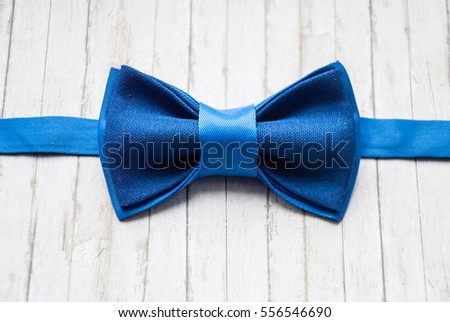 Bow tie on a wooden background. Accessory for formal dress. Men's casual. Men's and women's accessories. Men's and women's bow tie. Royalty-Free Stock Photo #556546690