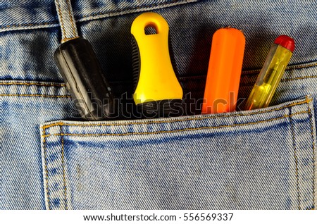 Different screwdrivers in a pocket of the blue jeans