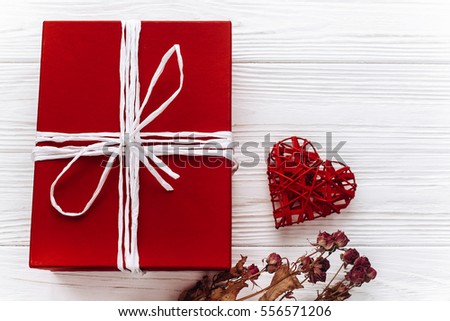 happy valentine day card concept. stylish red present and heart and roses on white rustic wooden background. greeting flat lay with space for text. 