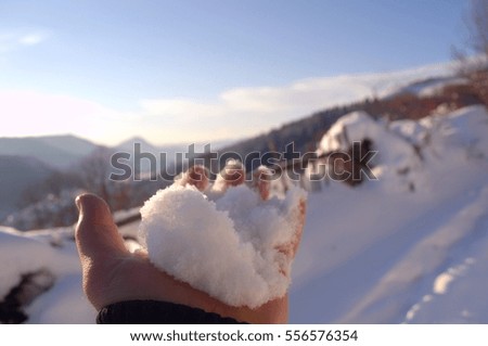 Winter motifs. Snow in the men's hand closeup. Enjoying a beautiful and sunny winter day.